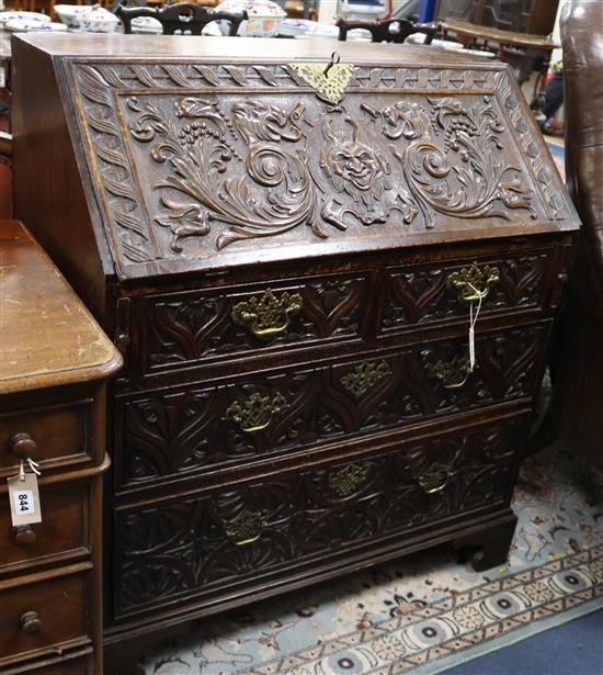 A carved oak bureau W.95cm